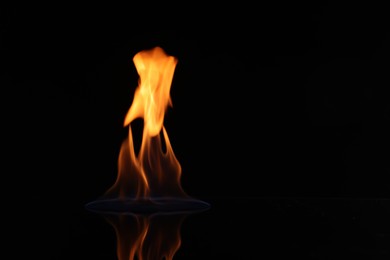 Photo of Beautiful view of flaming vodka on black background