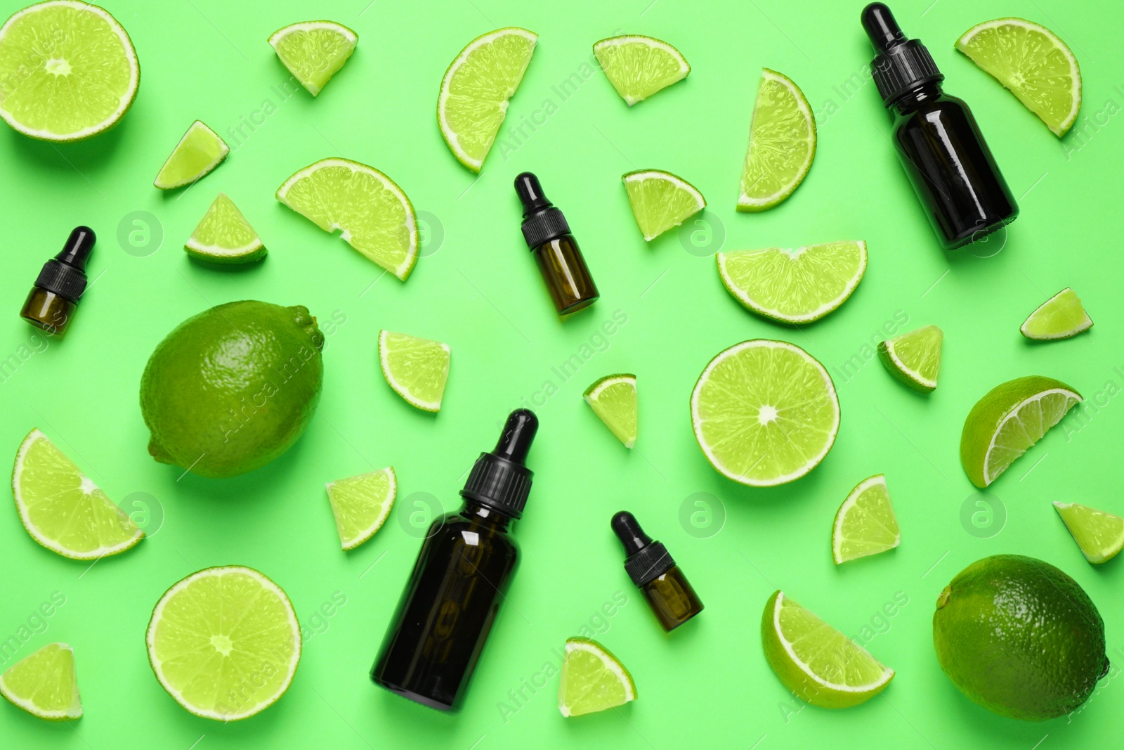 Photo of Flat lay composition with lime essential oil on green background