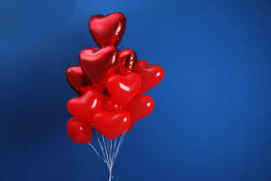 Bunch of heart shaped balloons on blue background, space for text. Valentine's day celebration