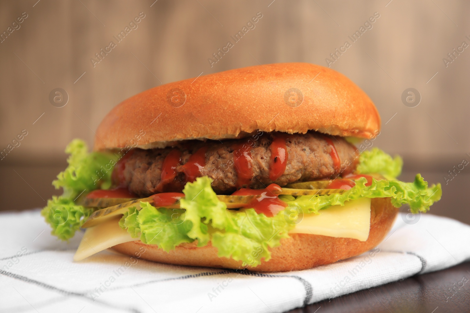 Photo of One tasty burger with patty, lettuce and cheese on table, closeup