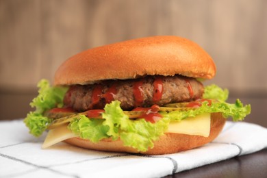 One tasty burger with patty, lettuce and cheese on table, closeup