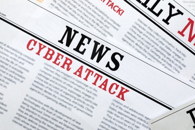 Newspapers with headlines Cyber Attack as background, closeup