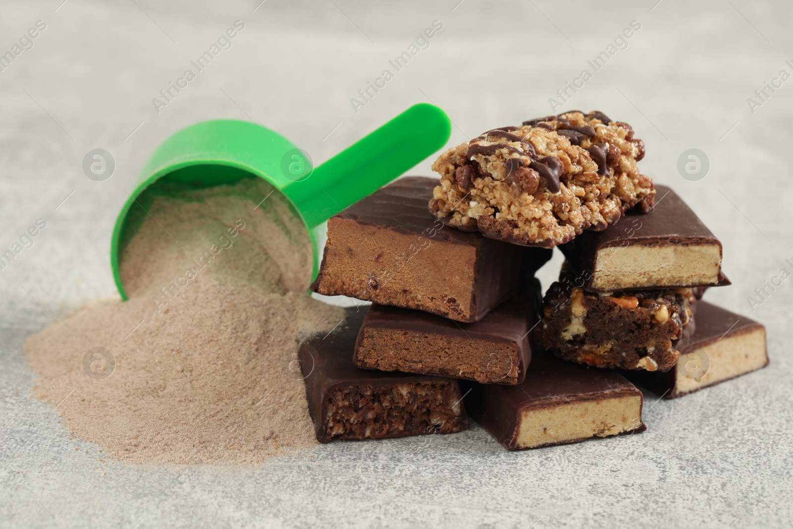 Photo of Different energy bars and protein powder on grey table, closeup