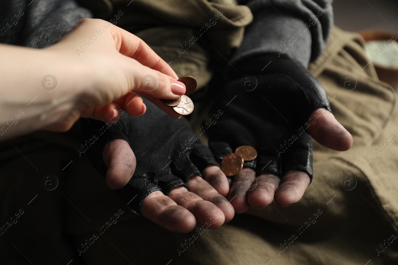 Photo of Woman giving coins to poor homeless man, closeup. Charity and donation