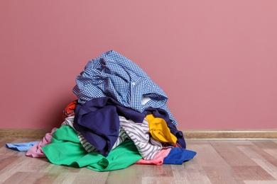 Photo of Pile of dirty clothes on floor near color wall