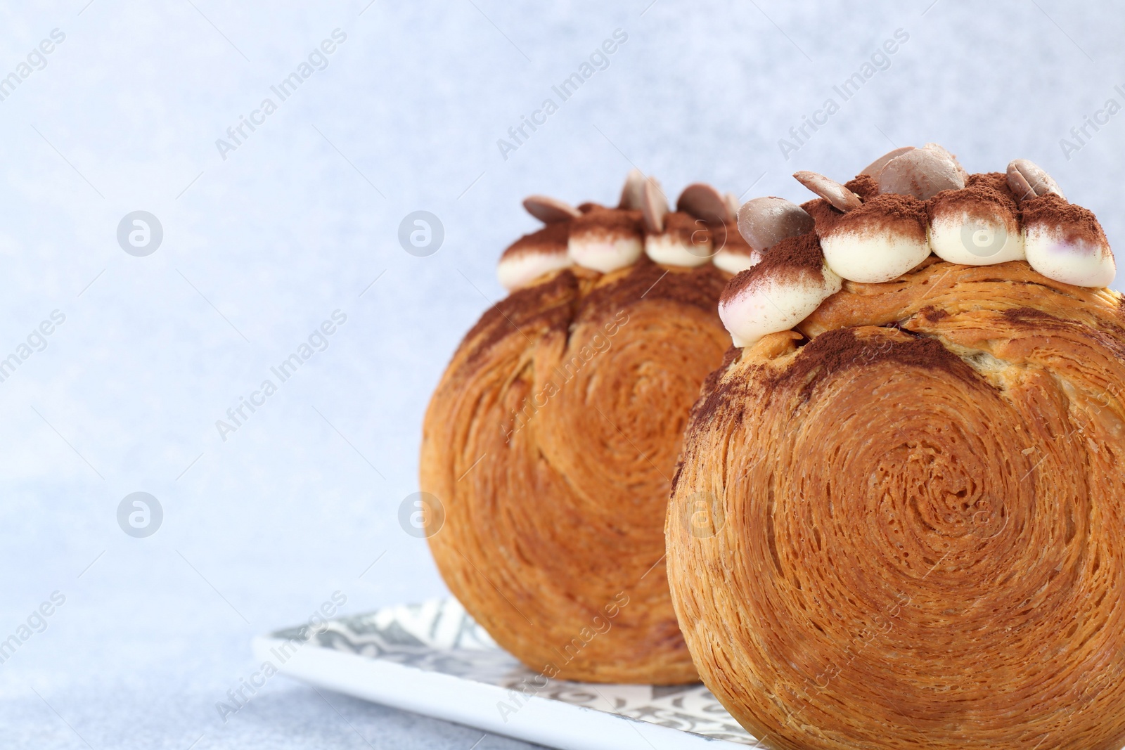 Photo of Tasty puff pastry. Supreme croissants with chocolate chips and cream on grey background, closeup. Space for text