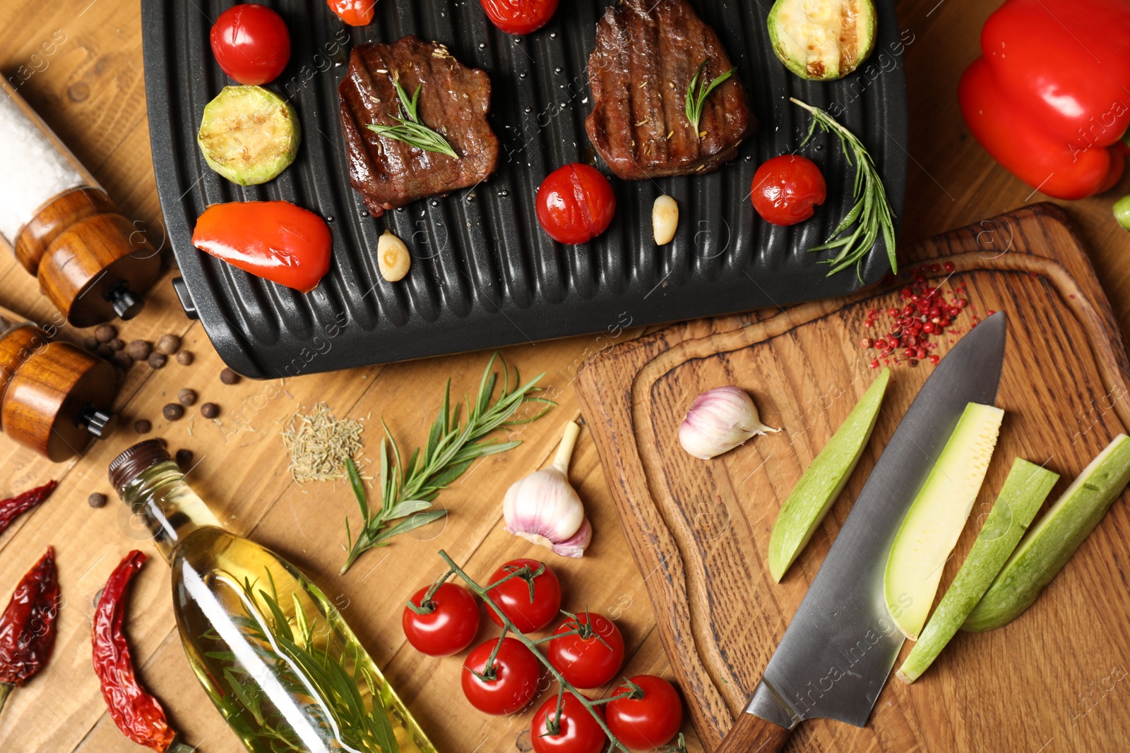 Photo of Flat lay composition with electric grill and different products on wooden table