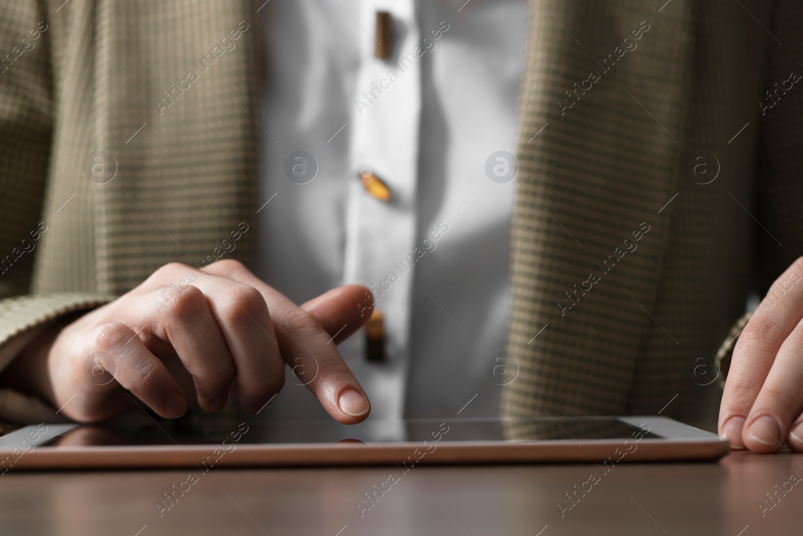 Photo of Closeup view of woman using modern tablet at table