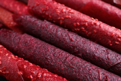 Delicious fruit leather rolls as background, closeup