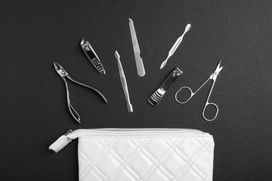Set of manicure tools and bag on black background, flat lay