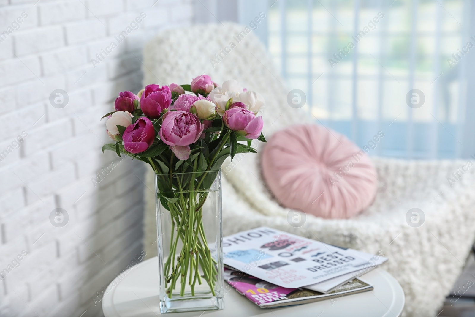 Photo of Vase with bouquet of beautiful peonies on table in room, space for text