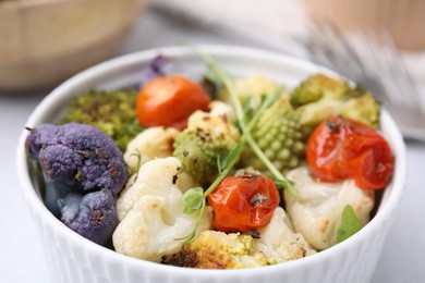 Photo of Delicious salad with cauliflower and tomato in bowl, closeup