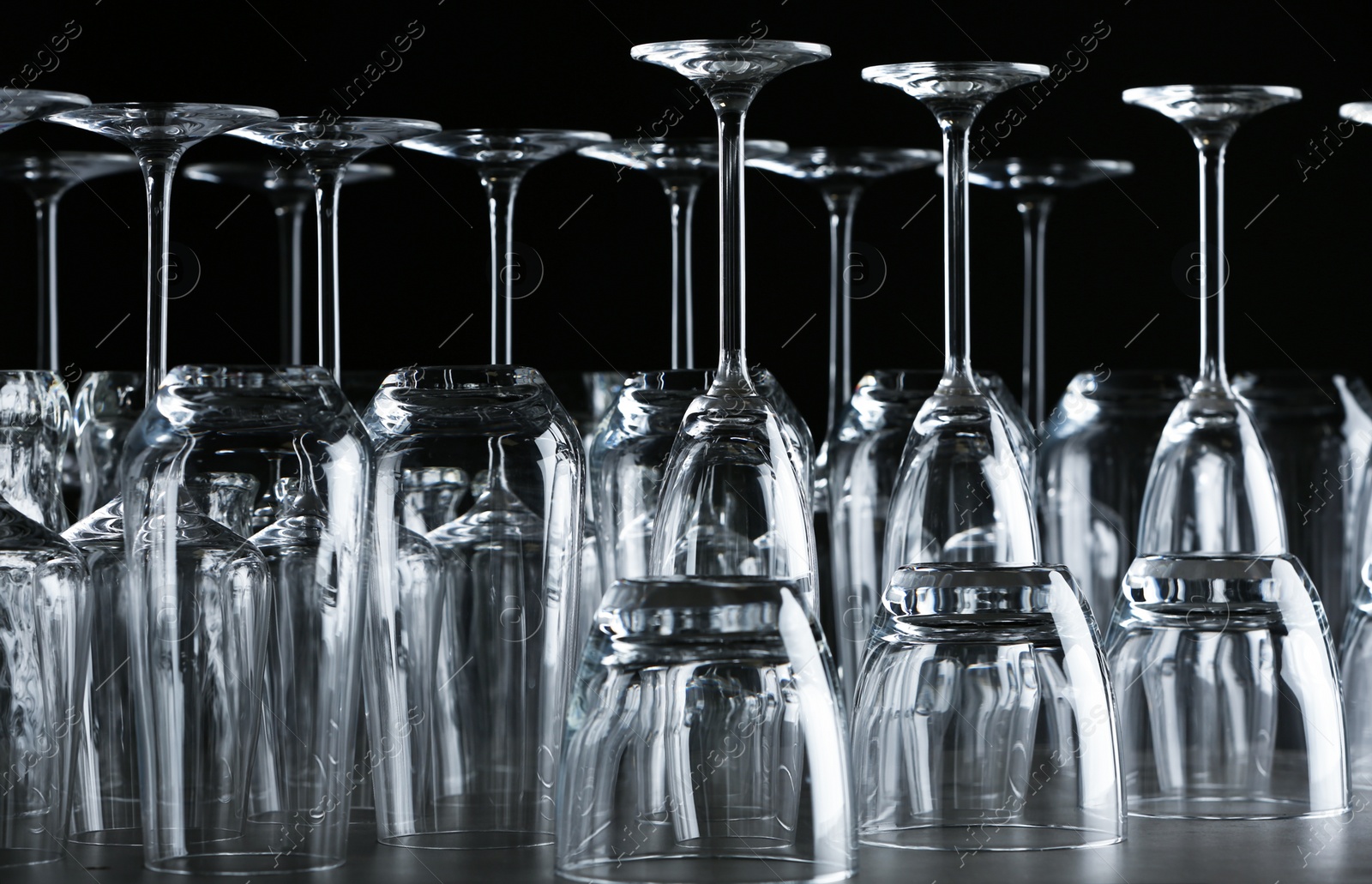 Photo of Set of empty glasses on table against black background