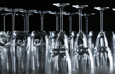 Set of empty glasses on table against black background