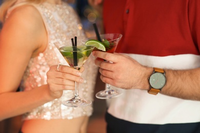 Photo of Young couple with tasty martini cocktails, closeup