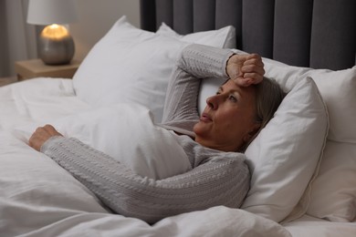 Photo of Menopause, night sweat. Woman suffering from hot flash in bed