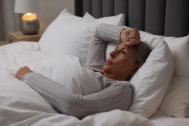 Menopause, night sweat. Woman suffering from hot flash in bed