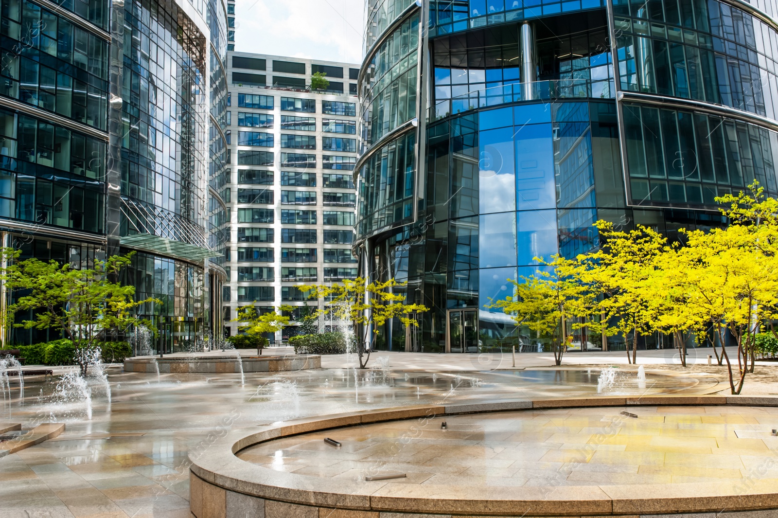 Photo of Beautiful fountain and trees near buildings in city