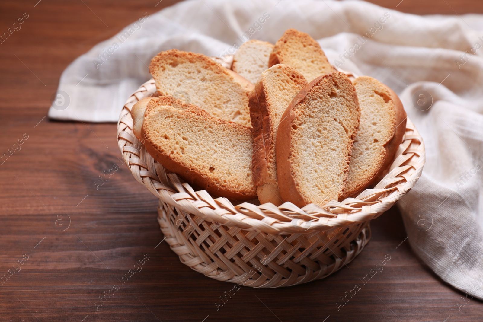 Photo of Hard chuck crackers in wicker basket on wooden table