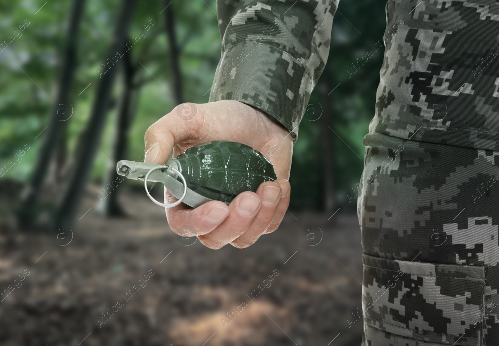 Image of Soldier holding hand grenade in forest, closeup