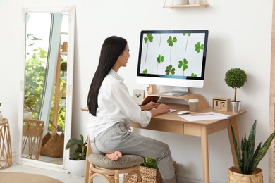 Photo of Young woman working at table in light room. Home office