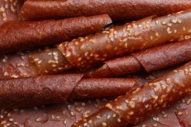 Photo of Delicious fruit leather rolls as background, closeup