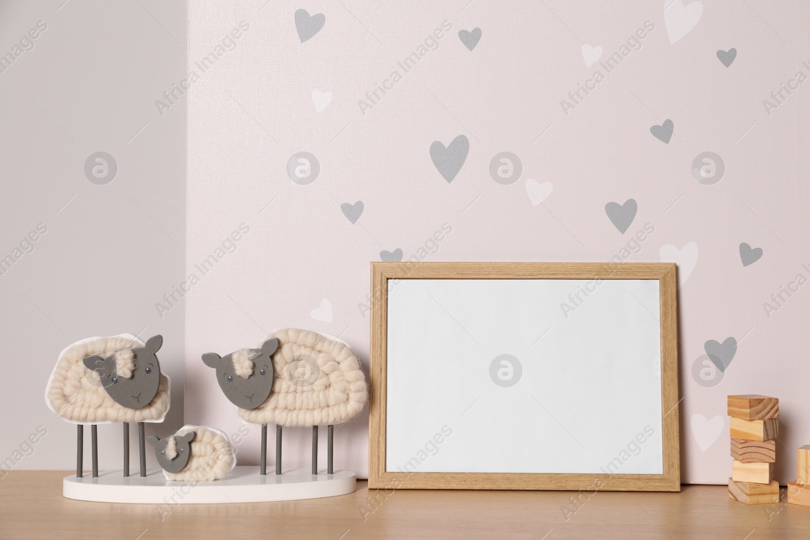 Photo of Empty square frame and different toys on wooden table