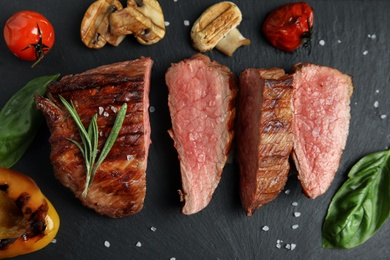 Photo of Flat lay composition with slices of grilled meat on slate board