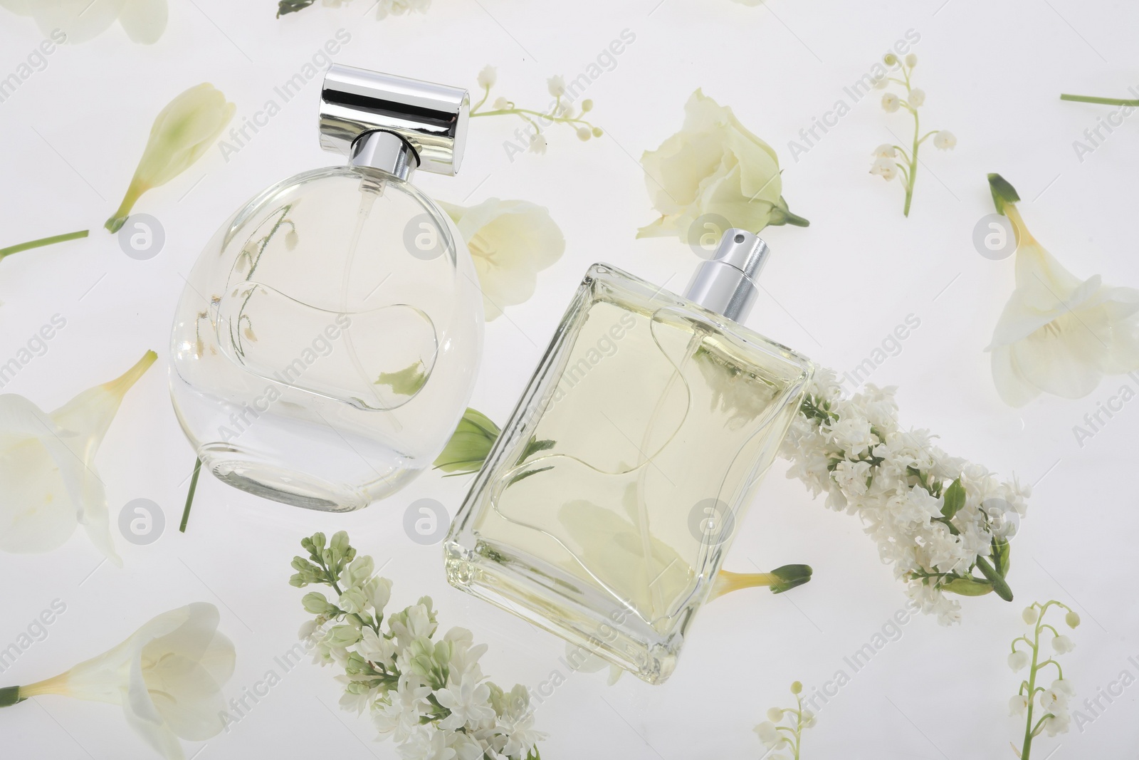 Photo of Luxury perfumes on spring floral decor, above view