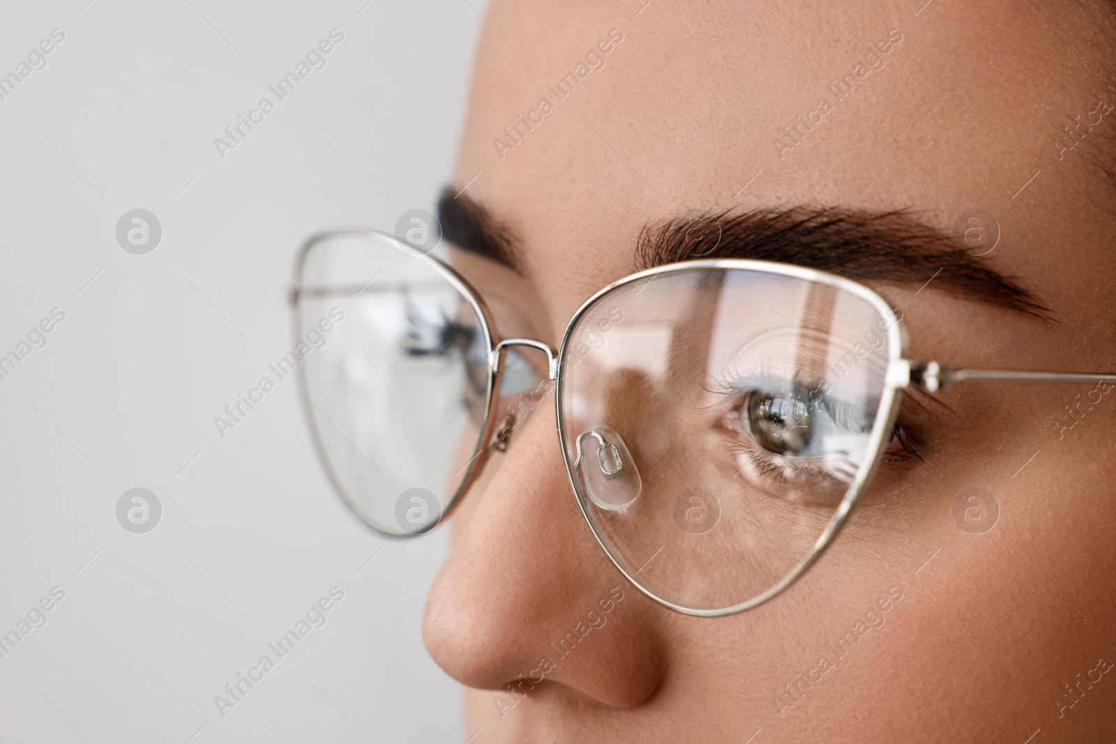 Photo of Woman wearing glasses on blurred background, closeup