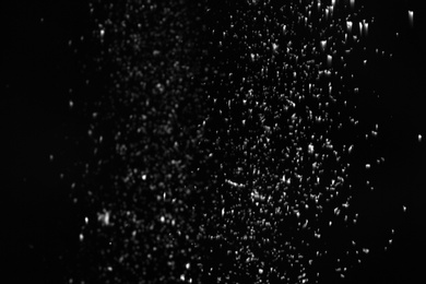 Photo of Snow flakes falling on black background. Winter weather