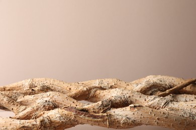 Photo of Presentation for product. Braided tree trunk on beige background. Space for text