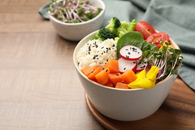 Photo of Bowl with many different vegetables and rice on wooden table, space for text. Vegan diet