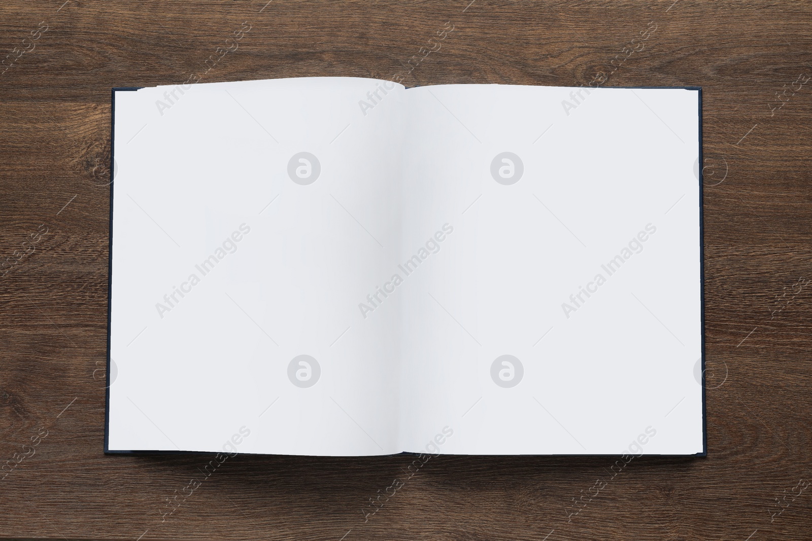 Photo of Open book on wooden table, top view