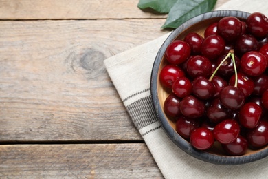 Photo of Sweet juicy cherries on wooden table, flat lay. Space for text
