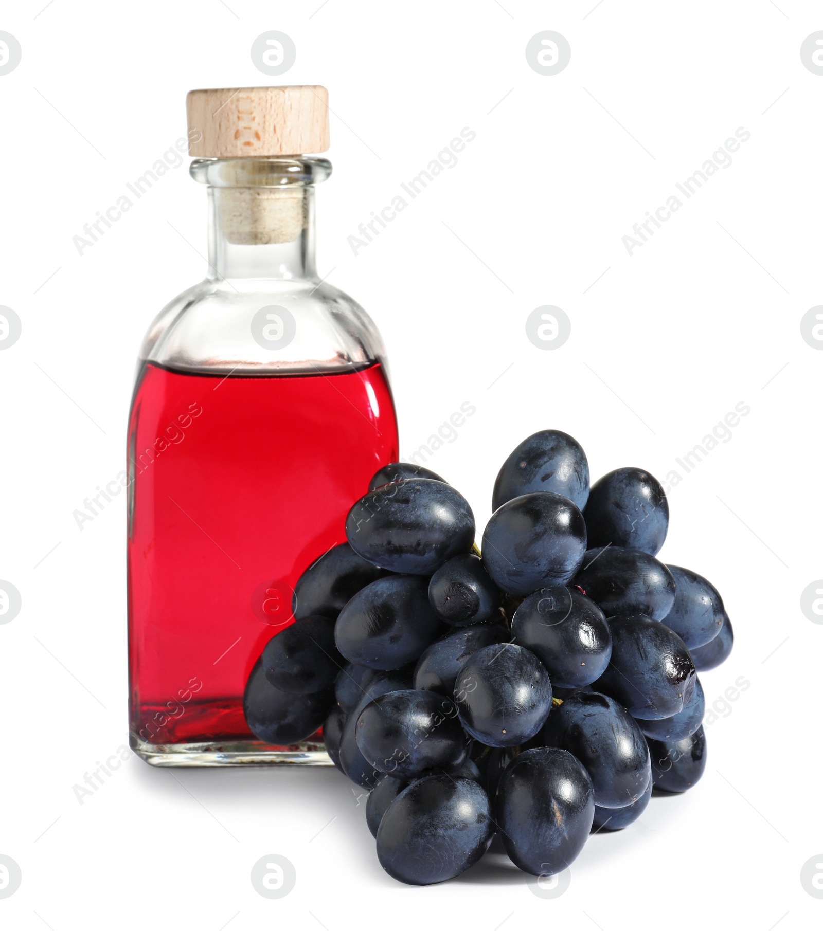 Photo of Glass bottle with wine vinegar and fresh grapes on white background