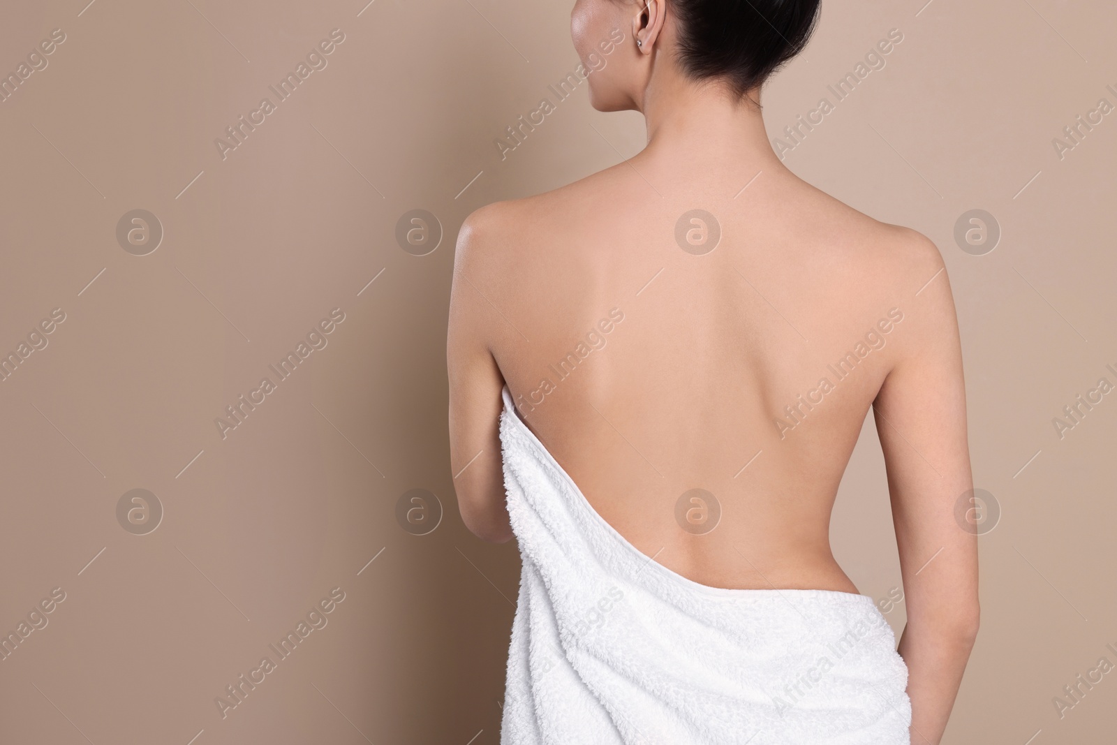 Photo of Back view of woman with perfect smooth skin on beige background, space for text