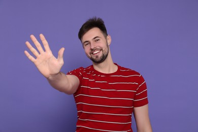Man giving high five on purple background
