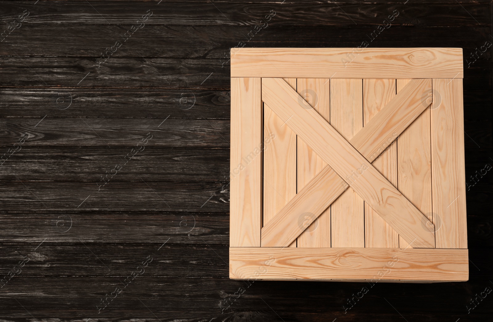 Photo of Wooden crate on dark background, top view with space for text