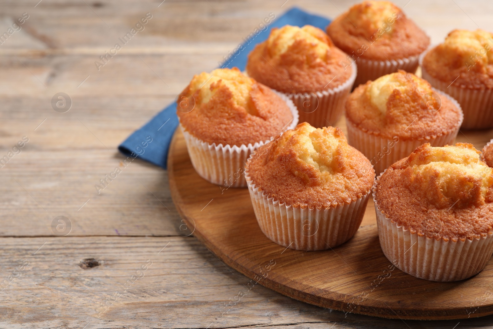 Photo of Delicious sweet muffins on wooden table, closeup. Space for text