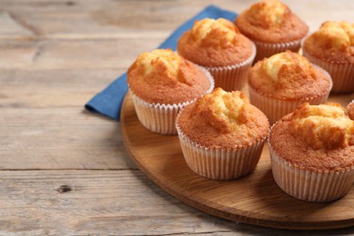 Photo of Delicious sweet muffins on wooden table, closeup. Space for text