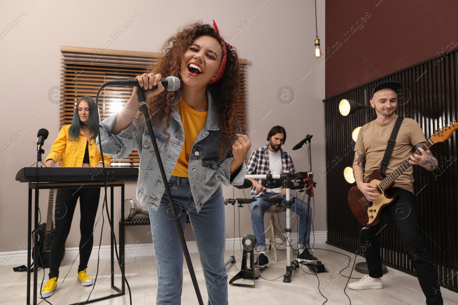 Photo of Music band performing in modern recording studio