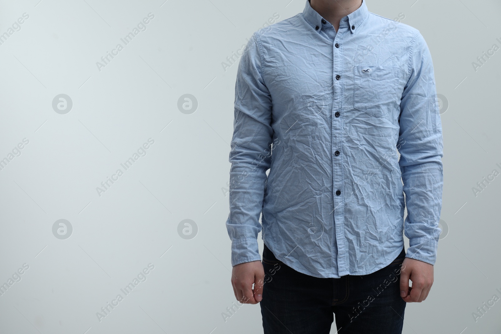 Photo of Man wearing creased shirt on light background, closeup. Space for text