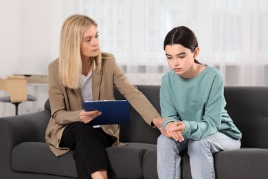 Photo of Psychologist working with teenage girl in office. Teenager problems