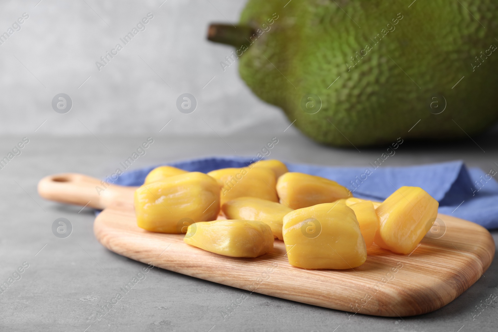 Photo of Delicious exotic jackfruit bulbs on light grey table