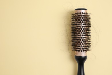 Photo of Professional brush with lost hair on beige background, top view. Space for text