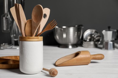 Photo of Set of different kitchen utensils on white wooden table against grey background