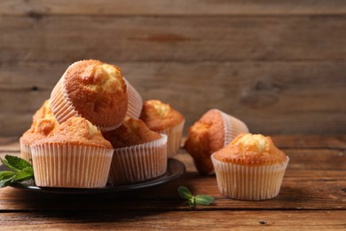 Delicious sweet muffins on wooden table, closeup