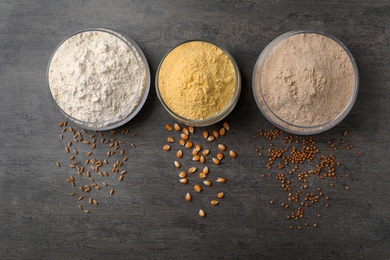 Photo of Jars with different types of flour on gray background