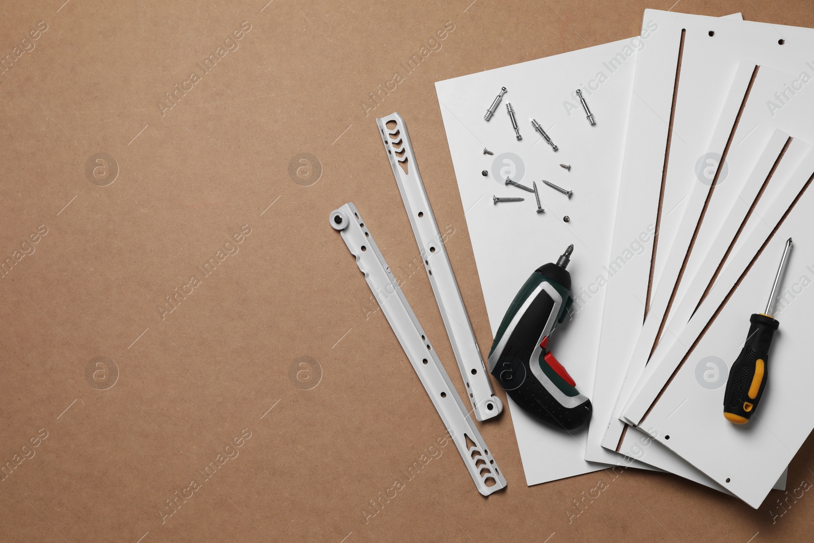 Photo of Furniture assembly parts and tools on brown background, flat lay. Space for text